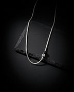 Necklace on a black mannequin bust against a white background