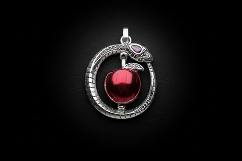 Silver pendant with a red apple on a white background.