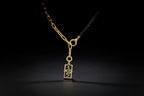 Gold necklace with a black pendant worn by a person on a white background