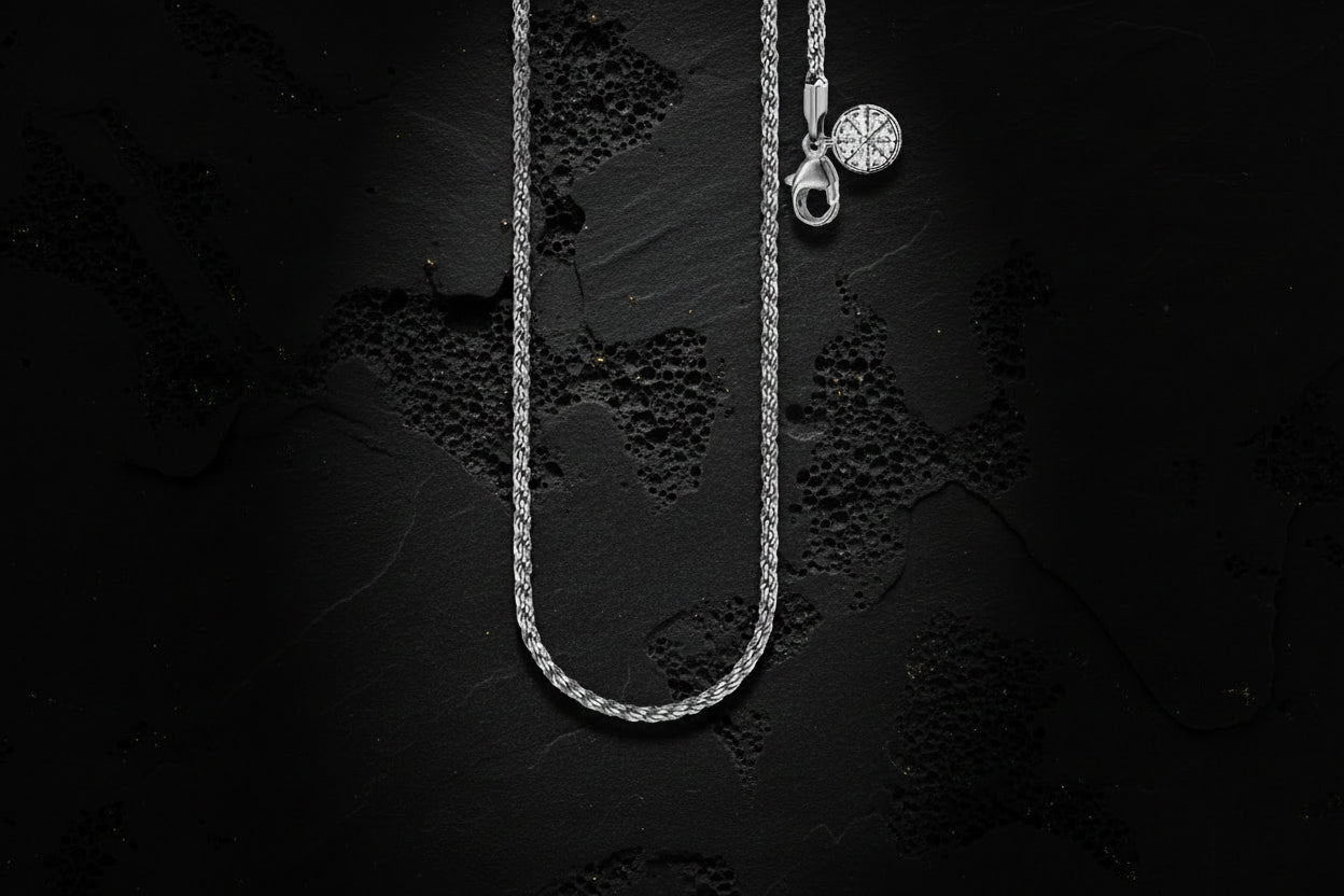 Silver necklace with a pendant on a textured black background